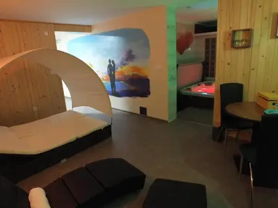a room with a bed and a table and a painting at Apartma Mihovc in Kamnik