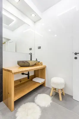 a bathroom with a wooden desk and a stool at Charming A&S Pohorje Apartments in Pohorje