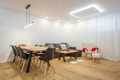 a dining room with a table and chairs and a couch at Charming A&S Pohorje Apartments in Pohorje