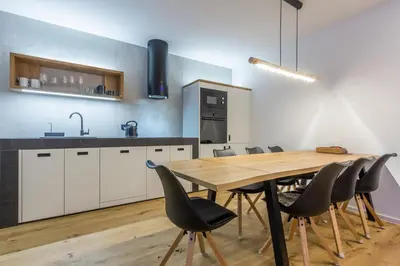 a kitchen with a wooden table and chairs at Charming A&S Pohorje Apartments in Pohorje