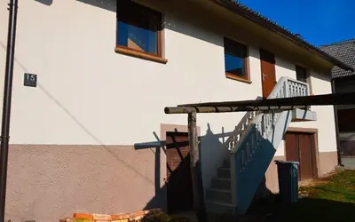 a house with a staircase leading up to a building at Granny Angela's house in Grosuplje