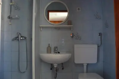 a bathroom with a sink and a toilet and a mirror at Granny Angela's house in Grosuplje