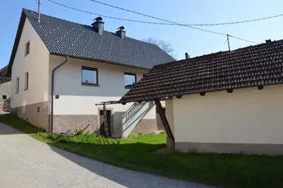 a white building with a staircase next to a house at Granny Angela's house in Grosuplje