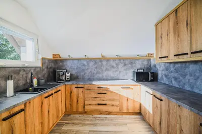 a kitchen with wooden cabinets and a window at Holiday Home Mountainview Horizon with Private Sauna & Hot Tub in Dravograd
