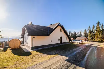 a large white building with a large wooden barrel at Holiday Home Mountainview Horizon with Private Sauna & Hot Tub in Dravograd