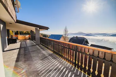 a balcony of a house with a view of the mountains at Holiday Home Mountainview Horizon with Private Sauna & Hot Tub in Dravograd