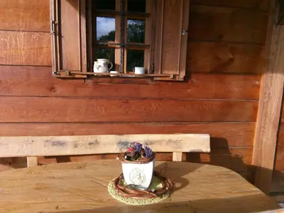 a table with a vase on top of a wooden bench at Holiday home in Otocec - Kranjska (Krain) 33898 in Otočec