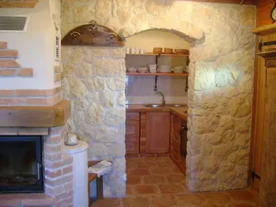 a kitchen with a stone wall and a fireplace at Holiday home in Otocec - Kranjska (Krain) 33898 in Otočec