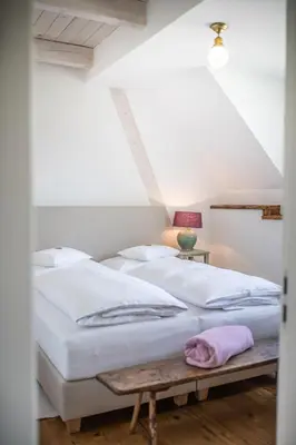 a bedroom with two beds and a table at Winzarei Ciringa Stampfer in Svečina