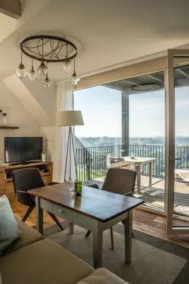 a living room with a table and a balcony at Winzarei Ciringa Stampfer in Svečina