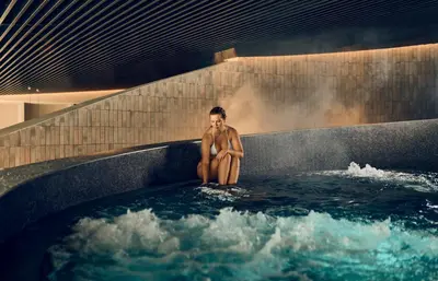 a man sitting in a bath tub with water at House of Eden- Private Family Holiday Home in Terme Catez with FREE Pool Tickets in Čatež ob Savi