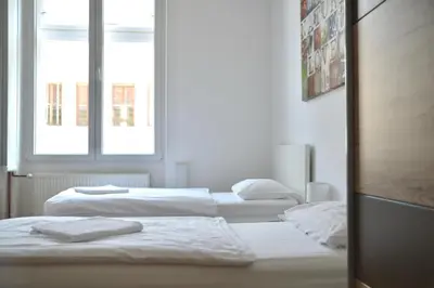 three white beds in a room with a window at Apartment Trdinova in Ljubljana