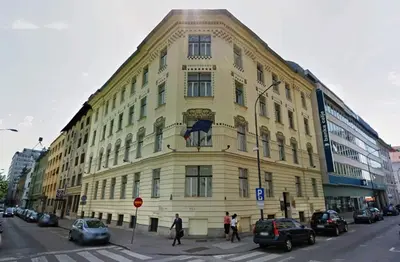 a large yellow building on the corner of a street at Apartment Trdinova in Ljubljana