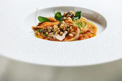 a white bowl of food on a white plate at Apartments Tabor in Naklo