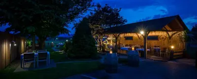 a restaurant with tables and chairs at night at Apartments Tabor in Naklo