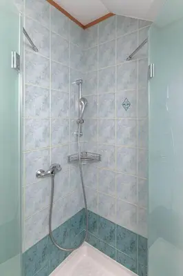 a shower with a glass door in a bathroom at Apartments Tabor in Naklo