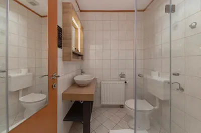 a bathroom with two toilets and a sink and a shower at Apartments Tabor in Naklo