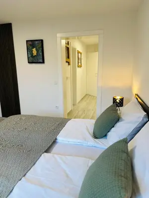 a bedroom with a bed with two pillows and a mirror at Montis Bled in Bled
