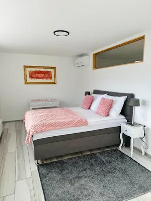 a bedroom with a bed with pink and white pillows at Montis Bled in Bled