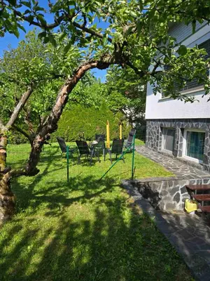 a yard with chairs and a table and a house at Montis Bled in Bled