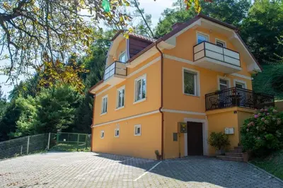 a yellow house with a balcony on top of it at Studio Belaj in Celje