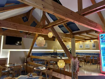 a restaurant with wooden ceilings and tables and chairs at Studio Belaj in Celje