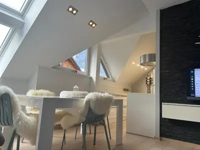 a dining room with a white table and chairs at Kranjska Gora Urban Apartment in Kranjska Gora