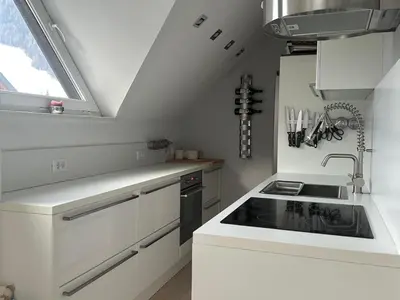 a white kitchen with a sink and a stove at Kranjska Gora Urban Apartment in Kranjska Gora