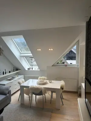 a living room with a white table and a couch at Kranjska Gora Urban Apartment in Kranjska Gora