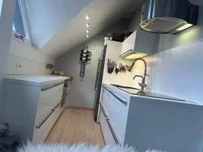 a kitchen with white cabinets and a sink at Kranjska Gora Urban Apartment in Kranjska Gora