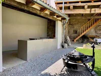 a grill in a yard next to a building at Vila Kobdilj 1835 Historic Homestead with Shared Courtyard in Štanjel