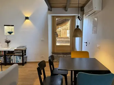 a dining room with a table and chairs at Vila Kobdilj 1835 Historic Homestead with Shared Courtyard in Štanjel