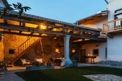 an outdoor patio with a wooden pergola at Vila Kobdilj 1835 Historic Homestead with Shared Courtyard in Štanjel