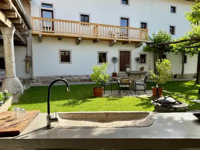 a garden with a sink in front of a building at Vila Kobdilj 1835 Historic Homestead with Shared Courtyard in Štanjel