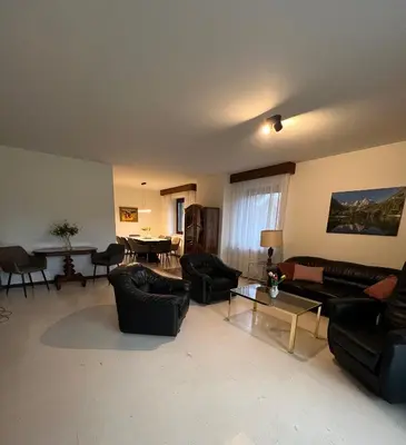 a living room with black couches and a table at Orchard Villa in Bled