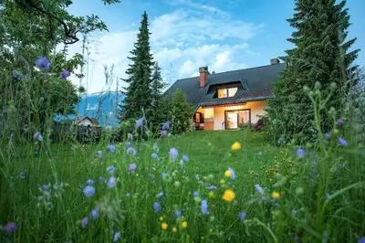 a house with a field of flowers in front of it at Orchard Villa in Bled