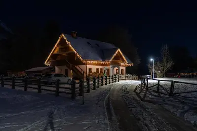 a house covered in lights in the snow at night at Hiša Erlah in Bohinj