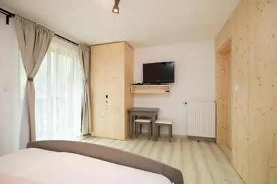 a bedroom with a bed and a desk and a television at Hiša Erlah in Bohinj