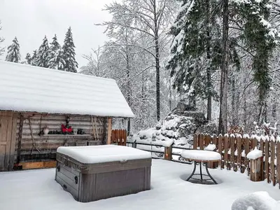 a snow covered yard with a sauna and a table at Hiša Erlah in Bohinj