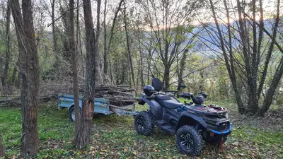 a motorcycle parked next to a trailer in the woods at Mala Savca in Loka pri Zidanem Mostu
