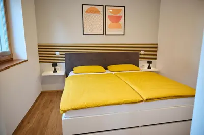 a bedroom with a bed with yellow sheets at Chili apartment in Žabnica