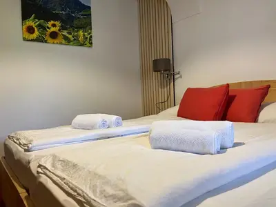 two beds in a hotel room with towels on them at Apartments Pri Boštjanovcu in Gorenja Vas