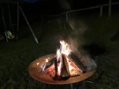 a piece of cake on a grill with fire at Apartments Pri Boštjanovcu in Gorenja Vas