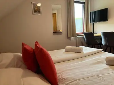 two beds in a hotel room with red pillows at Apartments Pri Boštjanovcu in Gorenja Vas