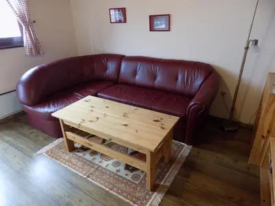 a brown leather couch in a living room with a coffee table at Apartment Zeleni dragulj Pohorje, mir & čudovita narava in Oplotnica