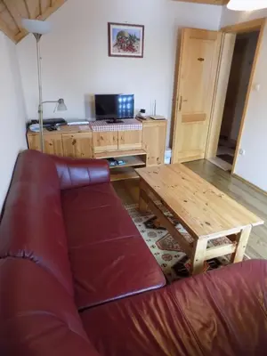a living room with a couch and a table at Apartment Zeleni dragulj Pohorje, mir & čudovita narava in Oplotnica