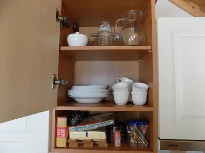 a cupboard with dishes and other items in it at Apartment Zeleni dragulj Pohorje, mir & čudovita narava in Oplotnica