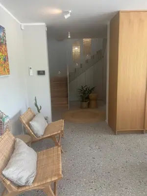 a hallway with wicker chairs and a staircase in a house at Vila Solini in Kozana