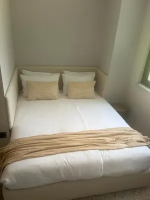 a bed with white sheets and pillows in a room at Vila Solini in Kozana