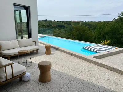 a patio with a swimming pool with chairs at Vila Solini in Kozana